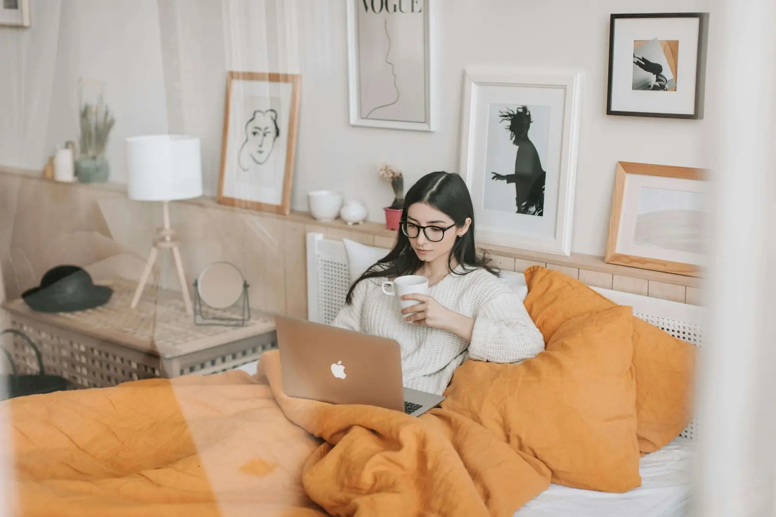 Une étudiante dans sa chambre, sur le lit, avec son PC