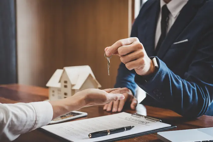 Image d'un homme tendant une clé à un investisseur qui a décidé d'investir dans une résidence étudiante