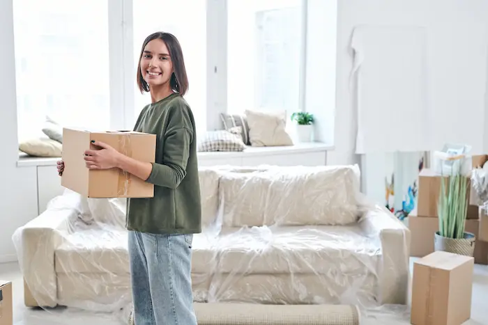 Une étudiante emménage dans son nouveau logement étudiant après avoir trouvé une solution, même sans garant pour location étudiant