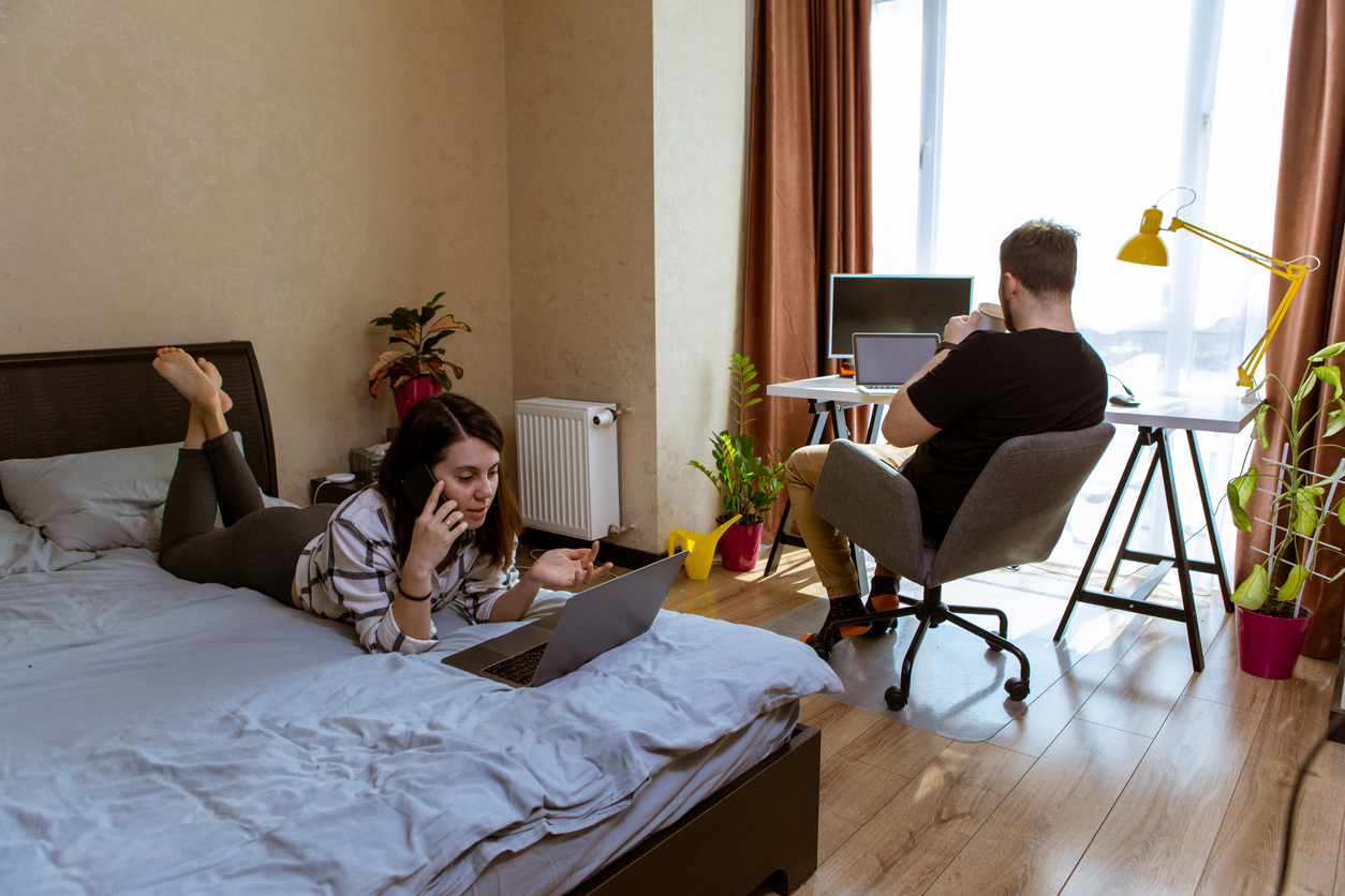 Homme et femme travaillent chacun dans un espace partagé en coliving à Besançon