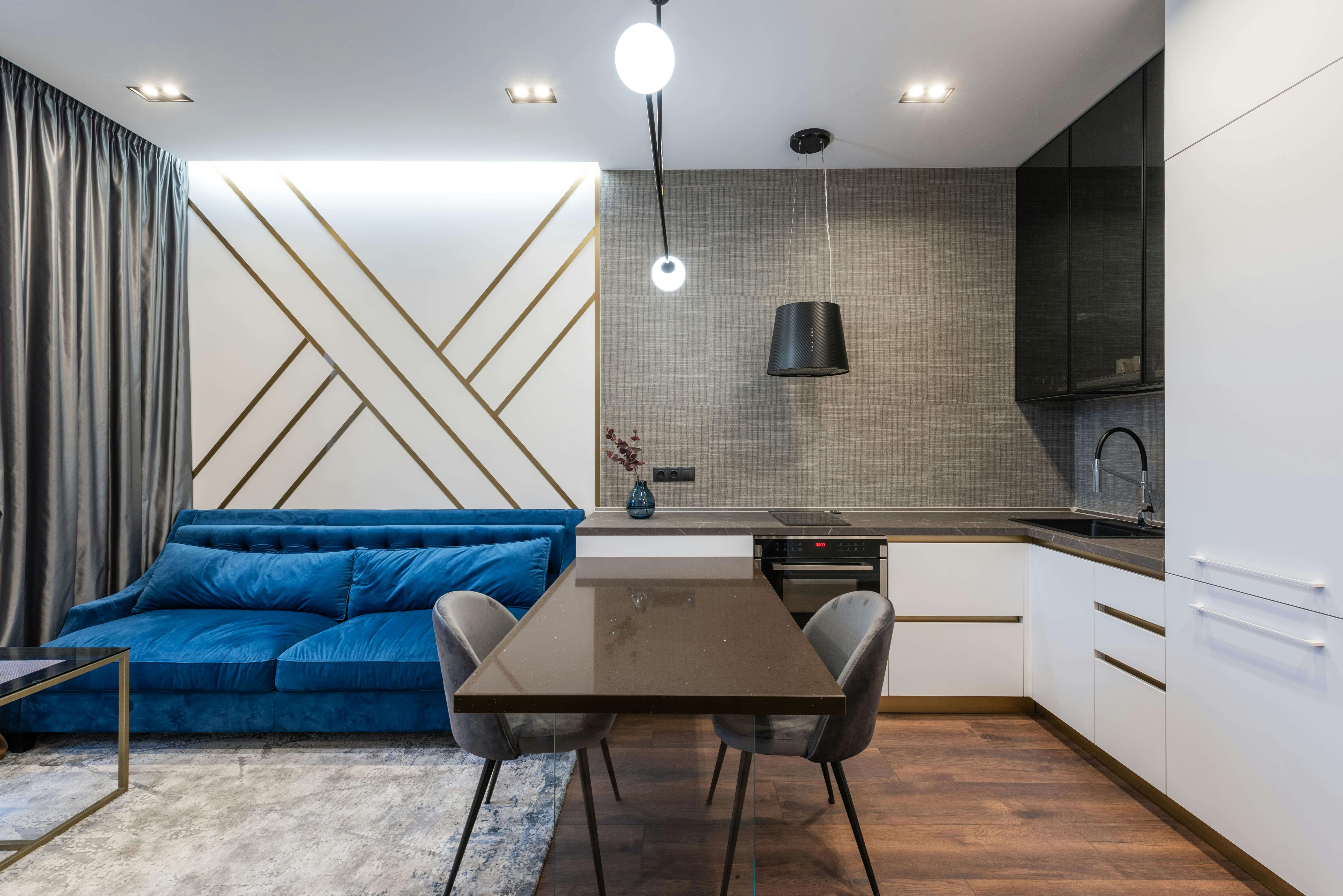 Un studio moderne comprenant une kitchenette, une table à manger et un salon qui sont séparés de la chambre à coucher.