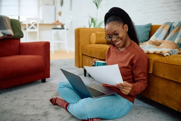 Une étudiante installée dans le salon de son appartement en colocation à Montpellier. Elle se réjouit des économies réalisées grâce à la colocation à Montpellier.