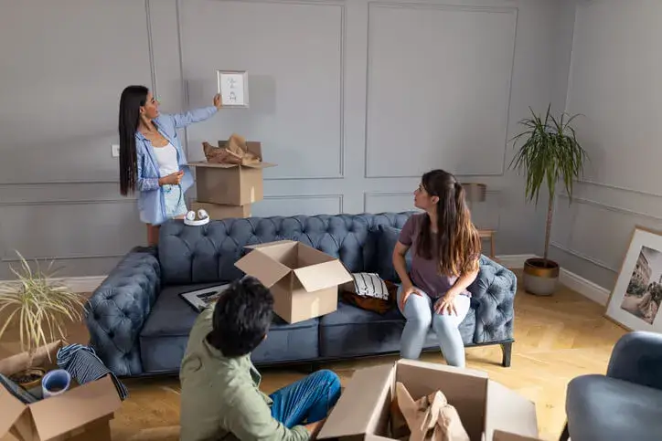 Des jeunes emménagent dans un logement en colocation à Brest, Ils déballent les cartons et décorent le salon.
