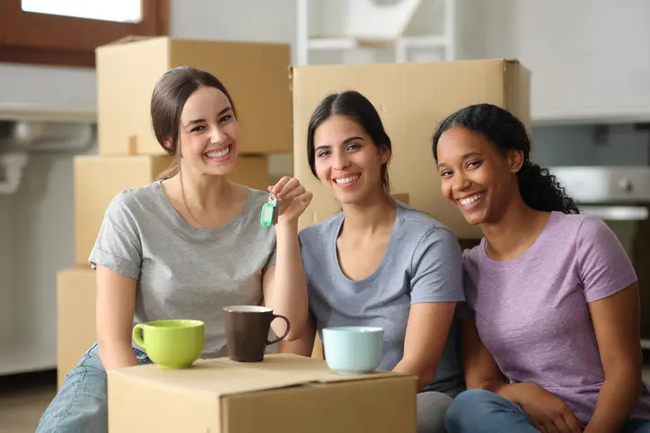 Trois étudiantes emménagent dans le salon de leur logement étudiant à Montélimar. Elles sont contentes de s'installer dans leur logement en colocation. 