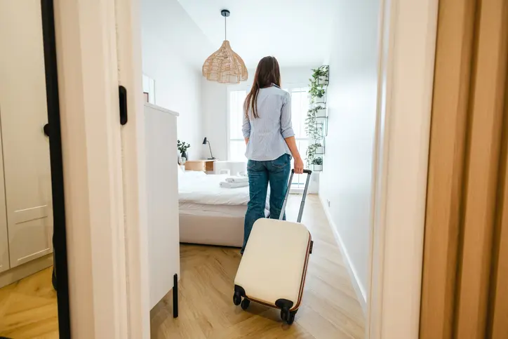 Photo d'une étudiante qui entre dans son logement en location courte durée, pour un stage de quelques semaines à Paris.