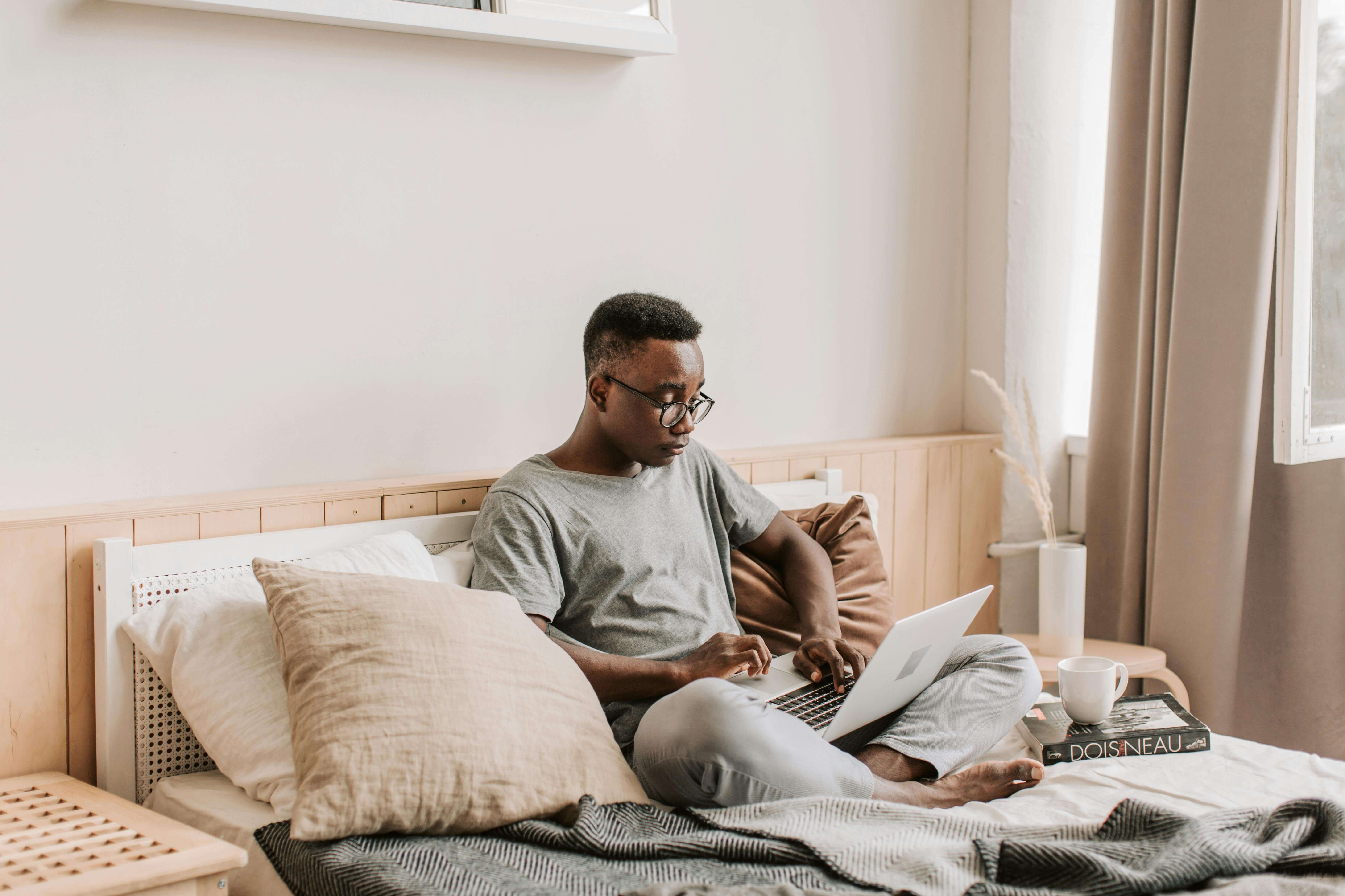 Logemen étudiant Paris 18 : Un étudiant qui est en train d'étudier confortablement dans sa chambre. Vous avez votre petit coin personnel dans une résidence étudiante. Les services inclus varient selon l'endroit.