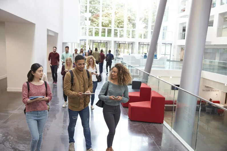 résidence étudiante à Agen : des étudiants discutent à la sortie de cours dans le bâtiment du campus. Vie étudiante et routine universitaire. 
