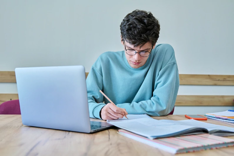résidence étudiante à Cergy : un étudiant travaille sur ses cours récents et se prépare aux prochains examens. Vie étudiante. Bureau et espace de travail pour universitaire en logement.