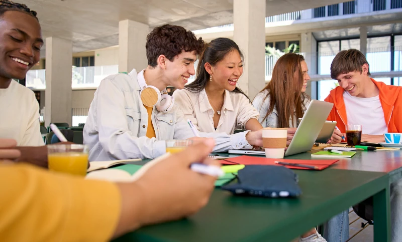 résidence étudiante à Colmar : les étudiants se rassemblent pour un travail de groupe. Apprentissage et entraide entre étudiants. Espace de travail en résidence et en université.
