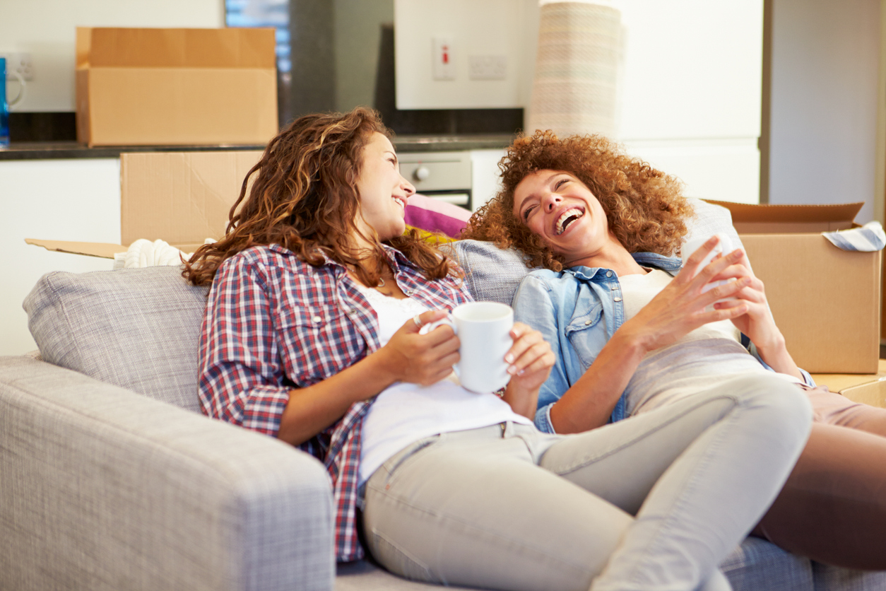 Deux jeunes filles discutent dans le salon d’un coliving à Lyon, dans un espace commun chaleureux et moderne.
