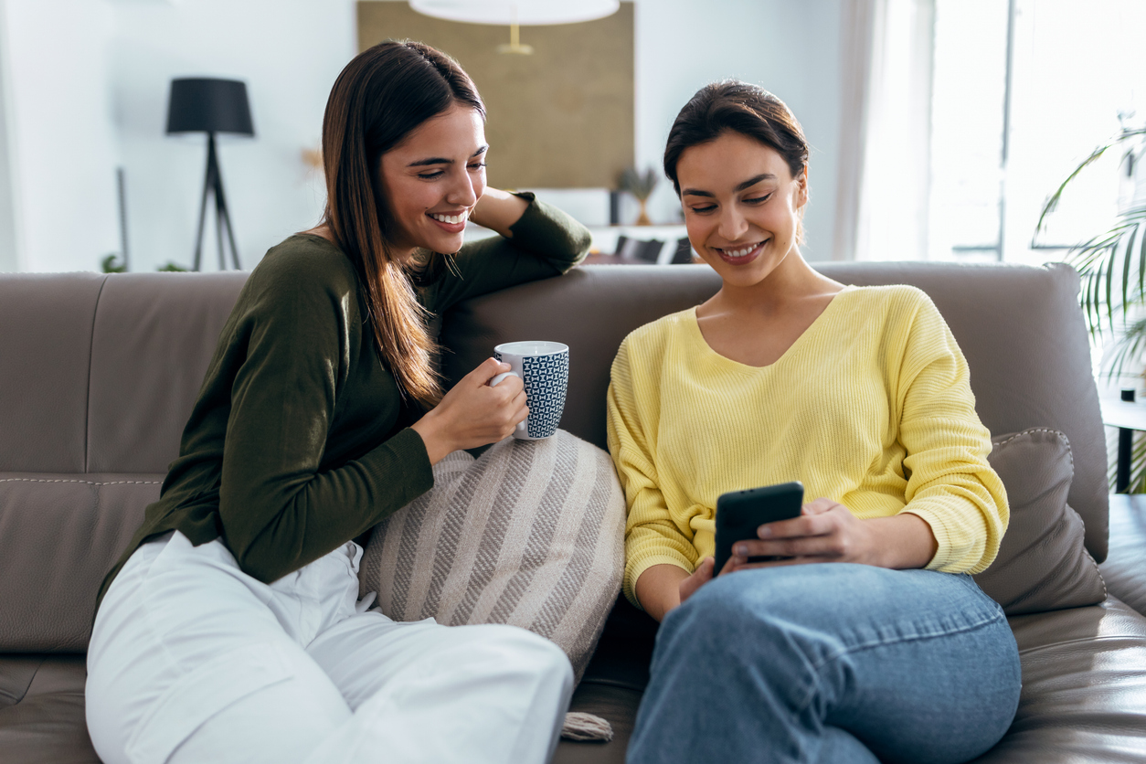 Deux filles dans un espace de coliving à Rome, partageant un moment convivial dans un salon commun.