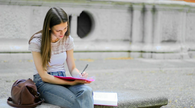 Résidence étudiante à Lille : une jeune étudiante révise seule dans son coin sur le campus.