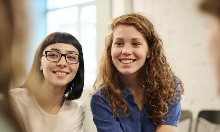 Deux filles prenant un selfie devant une maison lors d'une visite de logement