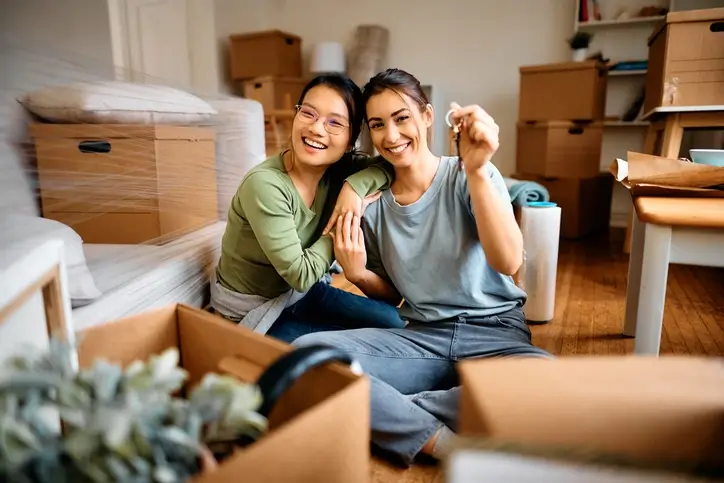 Deux étudiantes colocataires, contents de s'installer dans leur logement étudiant à Blois. Elles sont en plein emménagement, assises au milieu des cartons dans leur salon