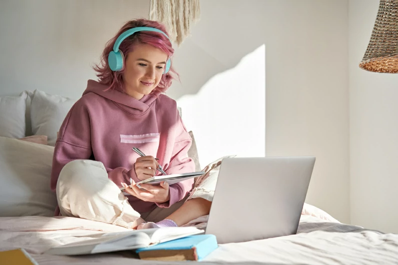 résidence étudiante à Montpellier : une étudiante révise ses cours sur son lit dans sa résidence. Elle prépare son évaluation. Logement étudiant et vie universitaire.