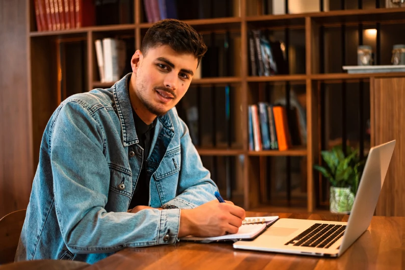 résidence étudiante à Courbevoie : un étudiant trouve ses marques et commence à étudier dans le bibliothèque du campus. Un endroit calme avec une ambiance studieuse.