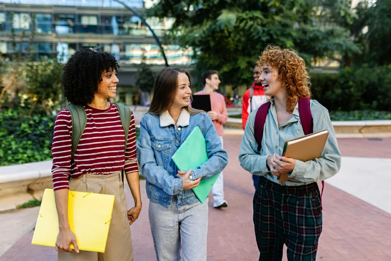 résidence étudiante à Drancy : trois étudiantes discutent dans la cours du campus. c'est l'avantage d'être à l'université, ce n'est pas seulement les études. Une occasion de se faire des ami(e)s et partager des moments ensemble. Ambiance jeune et vie estudiantine.