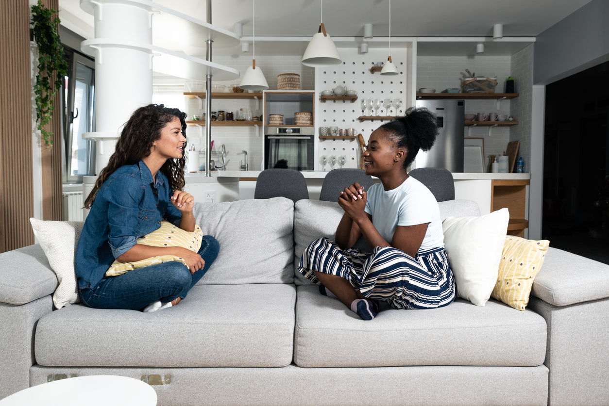Deux jeunes filles étudiantes discutent dans un coliving à Dijon, ambiance conviviale et moderne.