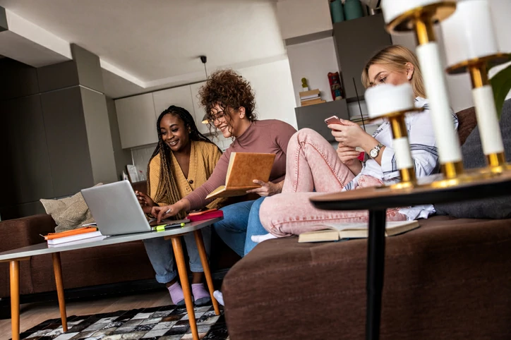 Logement étudiant Toulouse : des étudiantes sont en train de finir un devoir ensemble. Elles sont dans une pièce commune. On la retrouve souvent dans les résidences étudiantes.