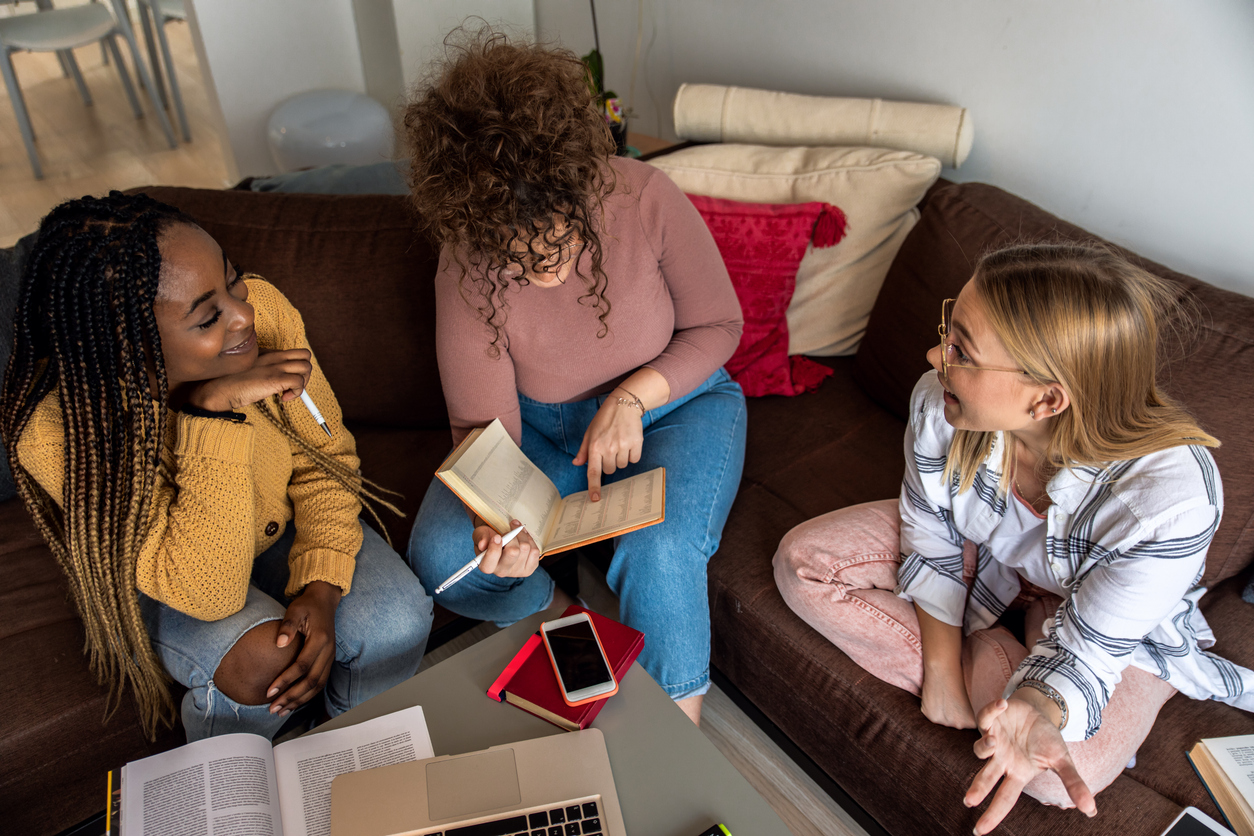 Trois filles dans un espace de coliving en Belgique, profitant d’une ambiance communautaire et chaleureuse.