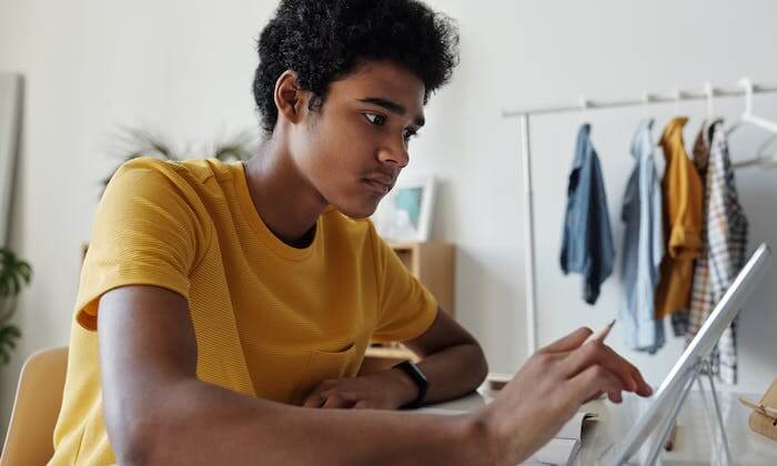 Un garçon assis utilisant sa tablette dans un studio