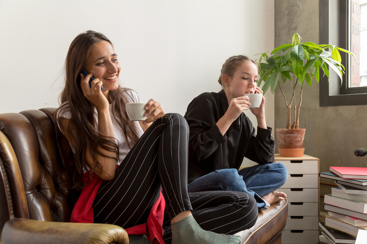 Deux jeunes filles dans un espace de coliving en Belgique, partageant un moment convivial.