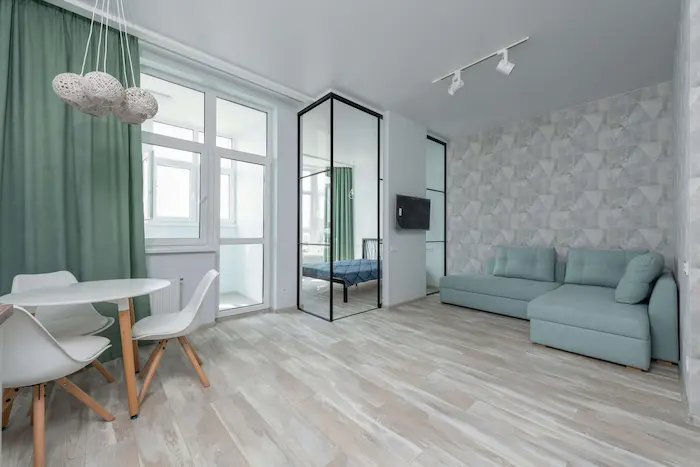 Un logement étudiant Valenciennes spacieux avec un aménagement moderne. Il comporte un salon, un lit et une table à manger.