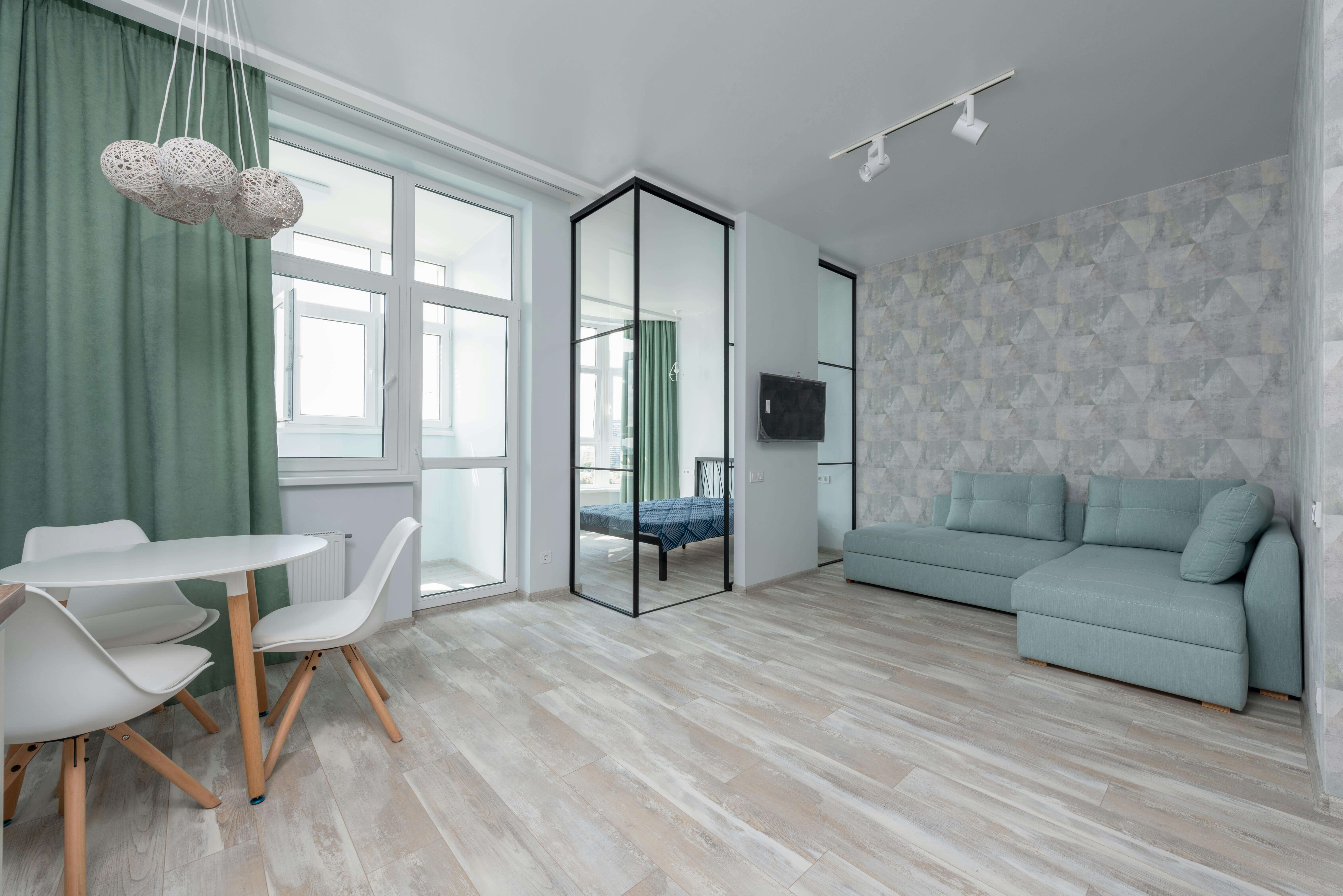 Un appartement spacieux avec un aménagement moderne. Il comporte un salon, un lit et une table à manger.