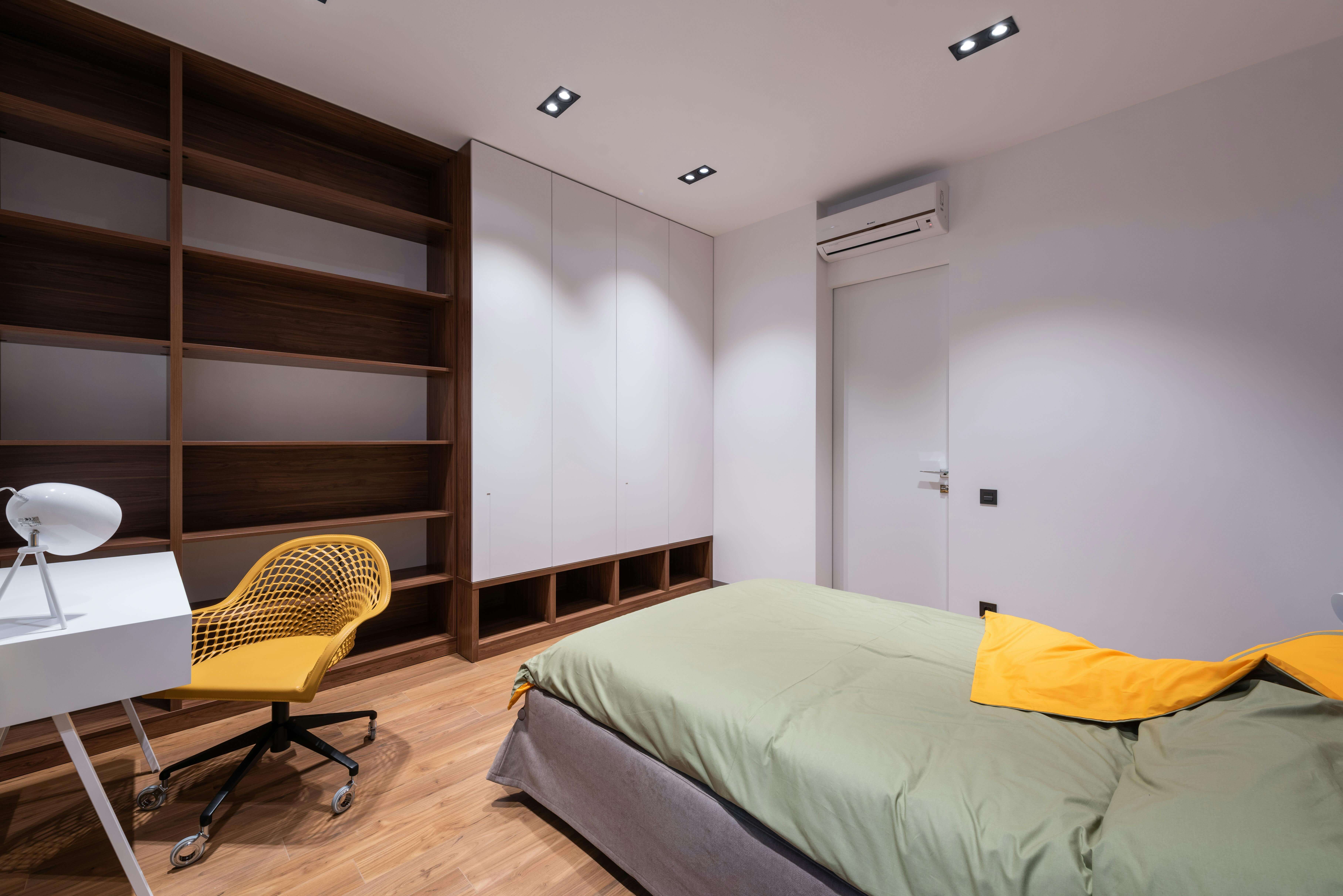 Une chambre pour étudiant à Montpellier avec une étagère, un lit et une table à manger.