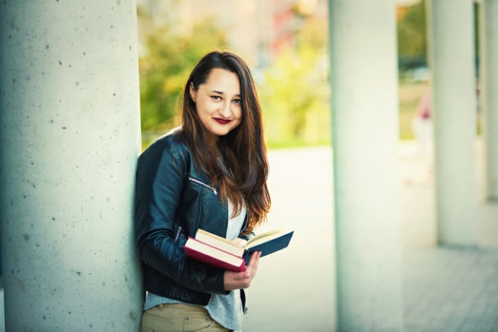 résidence universitaire à Limoges : une étudiante tient son bouquin dans la cours du campus.
