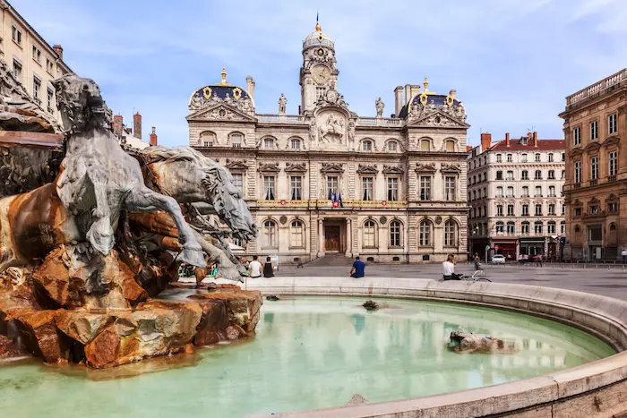 Ville de Lyon, mettant en avant la beauté de la ville. L'on voit la célèbre fontaine de Lyon et un logement où la colocation à Lyon est prisée.