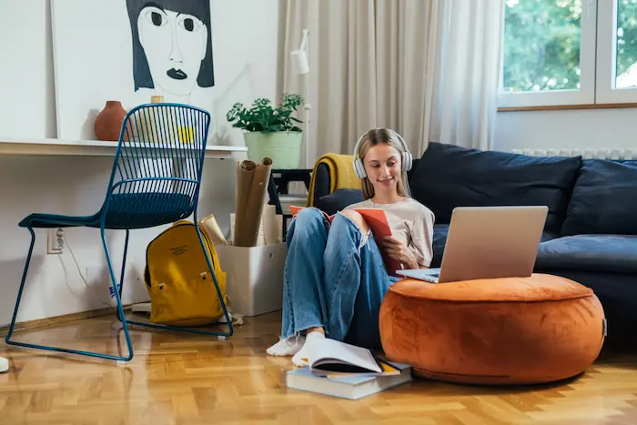 Une étudiante assise dans le salon de son logement étudiant APL, en train d'entamer les démarches pour bénéficier de l'aide de la CAF