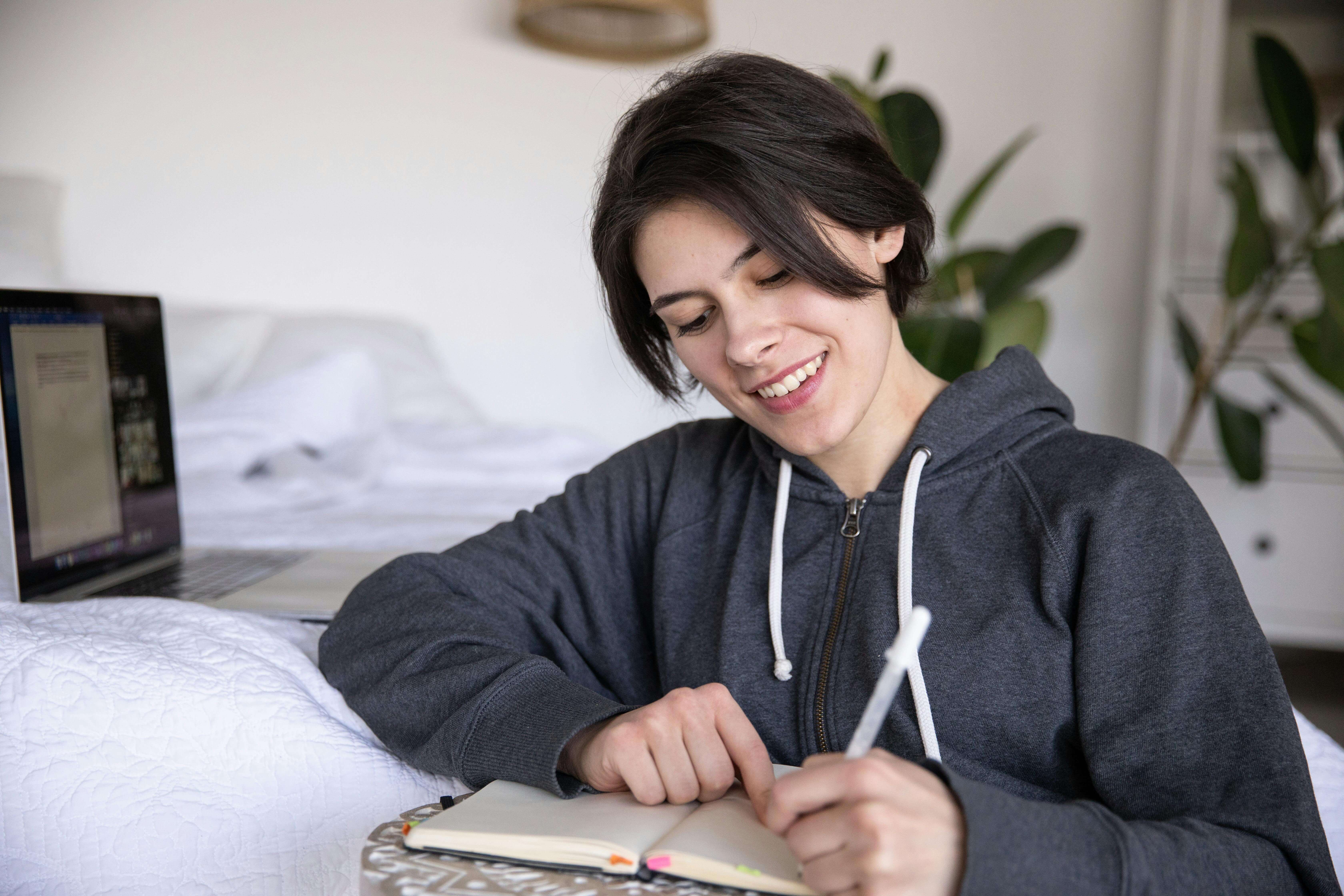 Une étudiante qui étudie confortablement dans sa maison.
